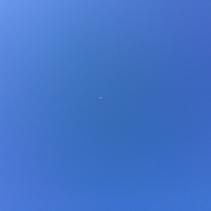 青空に小さく見える飛行機